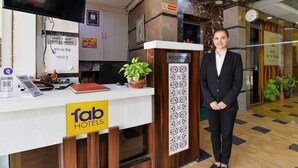 A reception desk with a sign reading "fab hotels," a clock, and a reception area. - Fabhotel Tip Top (Jaipur)