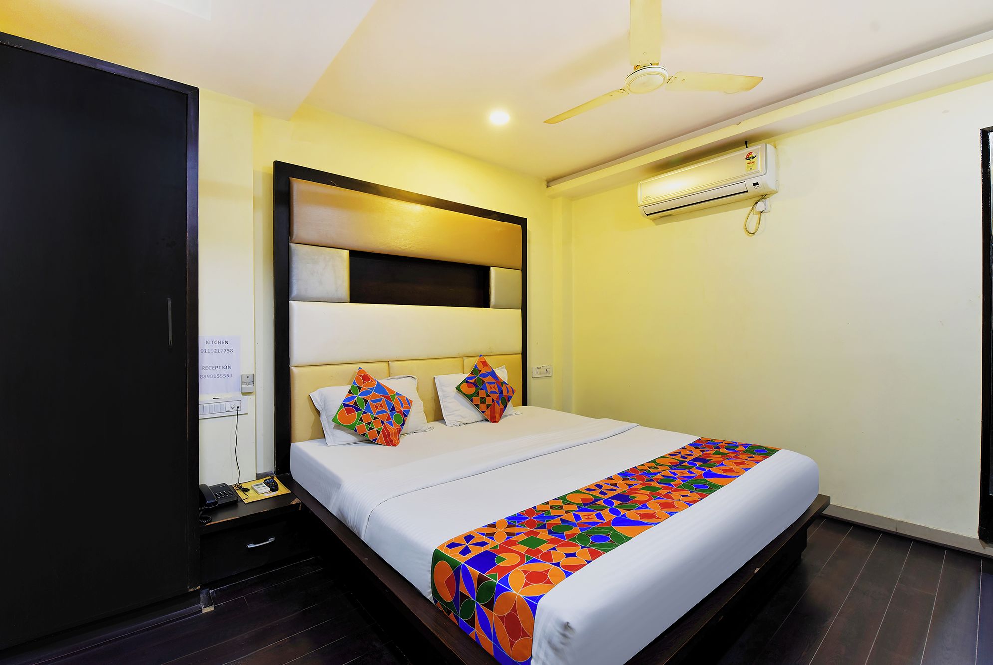 Une chambre d’hôtel équipée d’un lit, d’une armoire, d’un ventilateur de plafond et d’un appareil de climatisation.