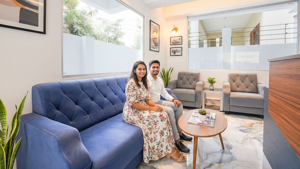 A modern living room with a blue sofa, a grey armchair, and a wooden coffee table.