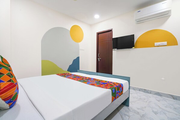 A hotel room with a bed, a TV mounted on the wall, and an air conditioning unit above it. - FabHotel Embassy Tribe - Continental Hospital & ISB, Financial District (Hyderabad)
