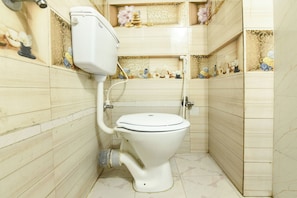 A compact bathroom with a toilet, a sink, and a shower.