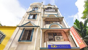 A hotel with a sign reading "fab hotels" and a "city place guest house" sign. - Fabhotel City Palace (Kolkata)