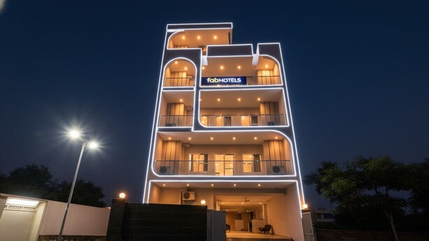 A multi-story hotel with a modern design, featuring balconies on each floor and a sign reading "fabHOTELS". - FabHotel Naveen Stay (Gurugram)