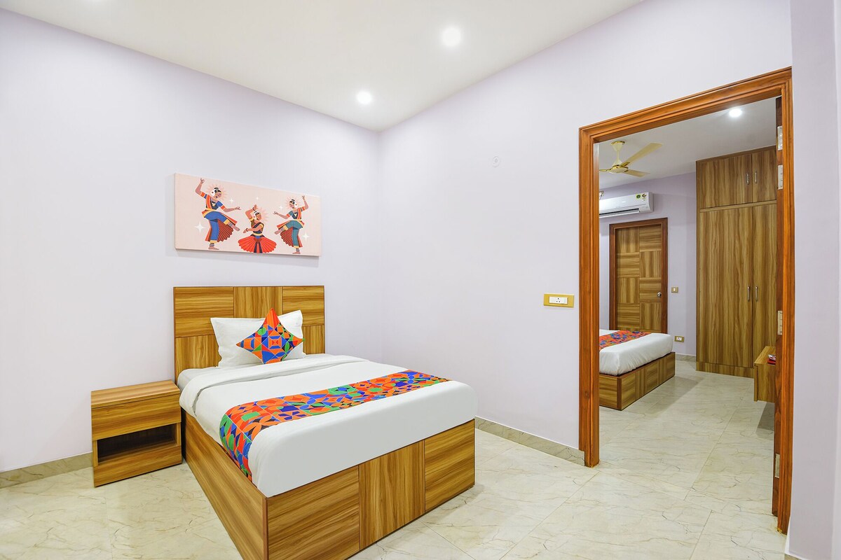 Un dormitorio con una cama de madera, una mesita de noche, un espejo y un ventilador de techo.