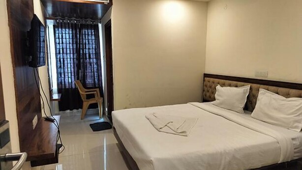 Une chambre d’hôtel avec un lit, une chaise et un téléviseur.