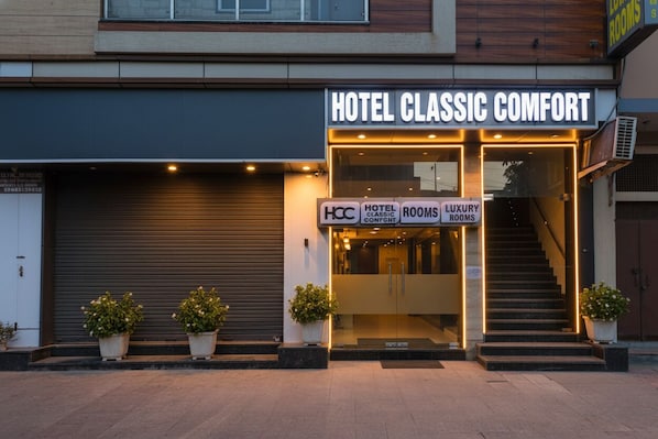 A hotel entrance with a sign reading "HOTEL CLASSIC COMFORT" and "LUXURY ROOMS".