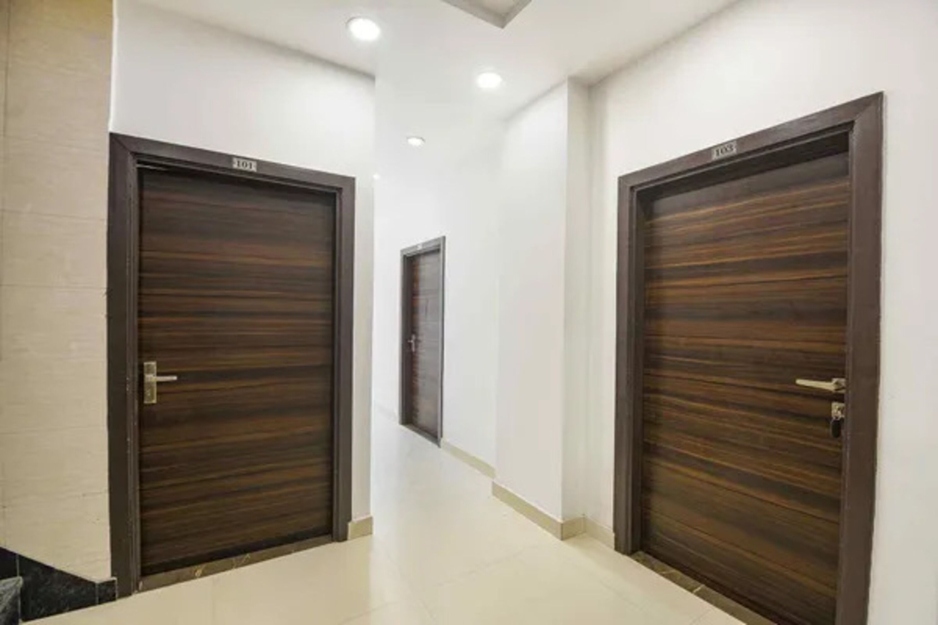 A hallway with two dark wooden doors, each marked with a number.