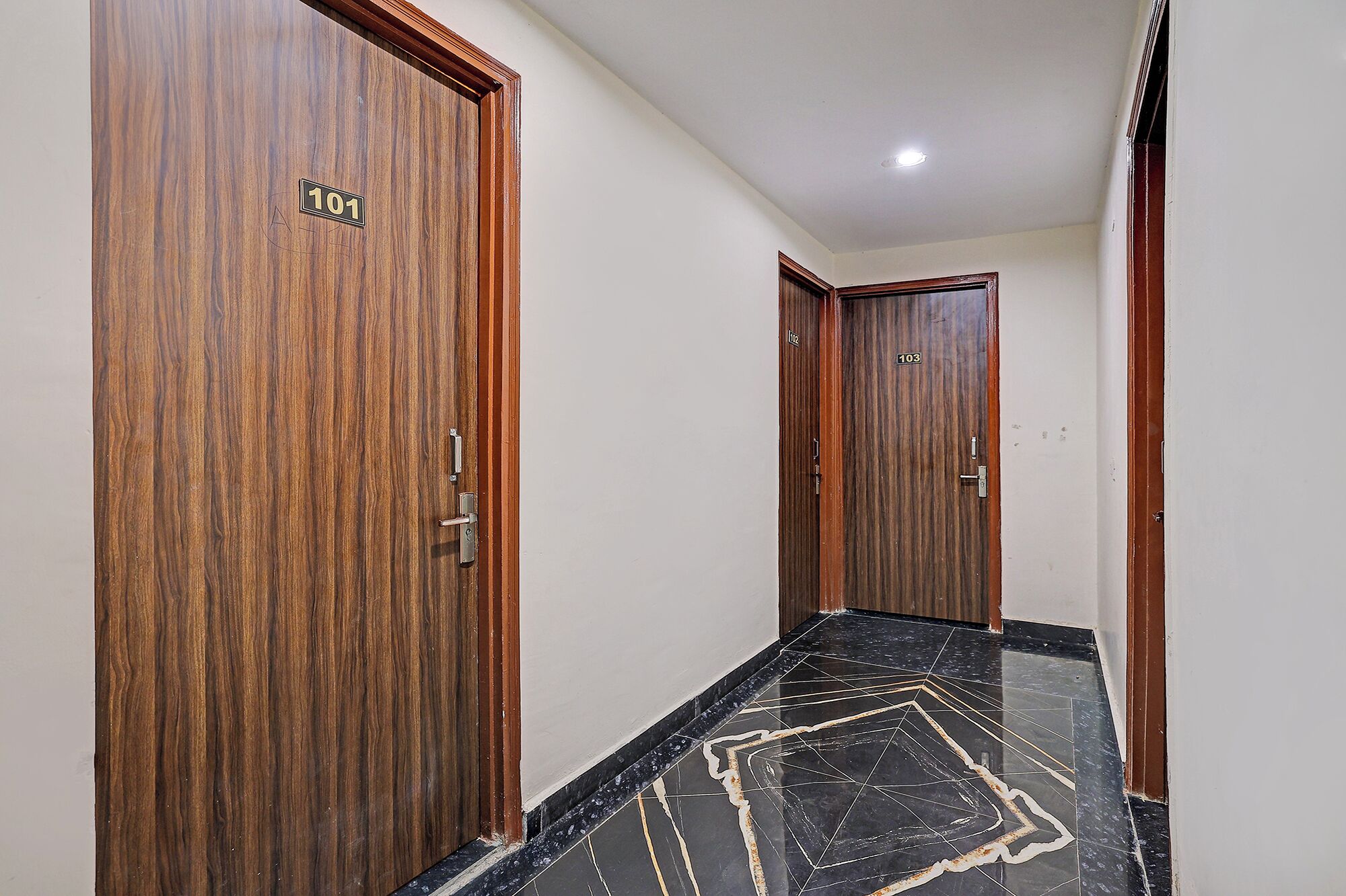 A hallway with wooden doors numbered 101 and 103, leading to rooms.