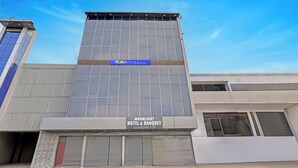 Un edificio moderno con un letrero que dice 'Tab Hotels' y 'Moonlight Hotel & Banquet'.