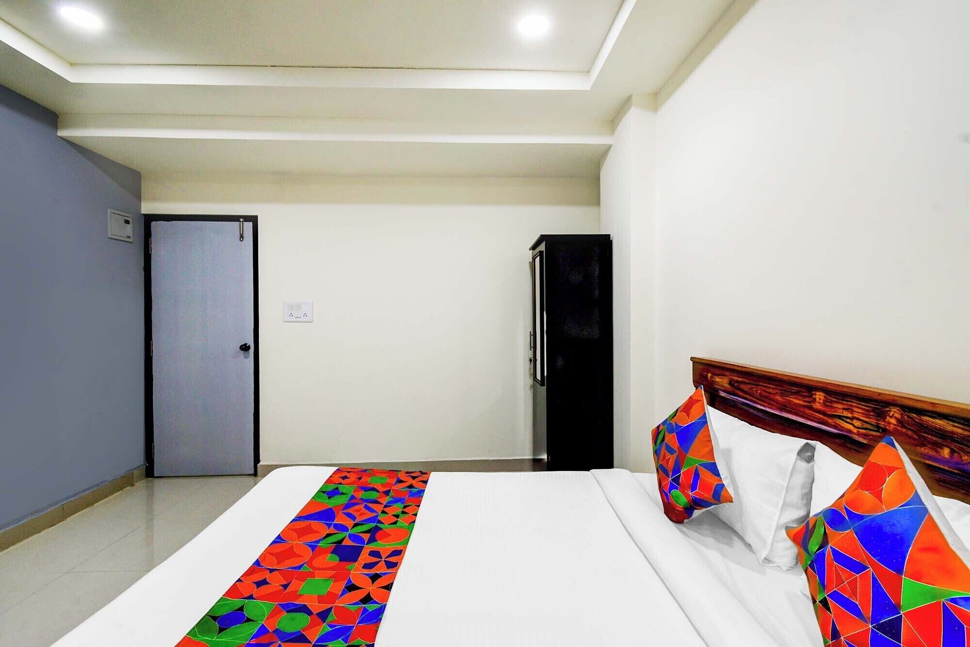 A hotel room with a bed, a wardrobe, and a door.