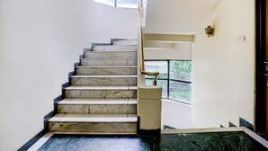 Un escalier avec des marches en marbre menant à un palier.