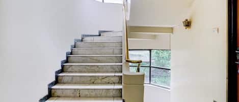 Eine Treppe mit Marmorstufen, die zu einer Empore führt.