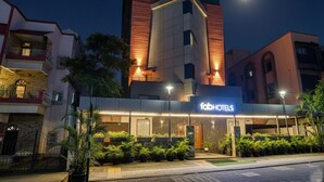 Un hôtel moderne doté d’une façade remarquable, d’une entrée bien éclairée et d’un espace extérieur aménagé avec des plantes en pot.