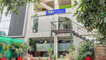 A hotel with a modern facade, a visible sign reading "fabHOTELS", and a staircase leading to the entrance.