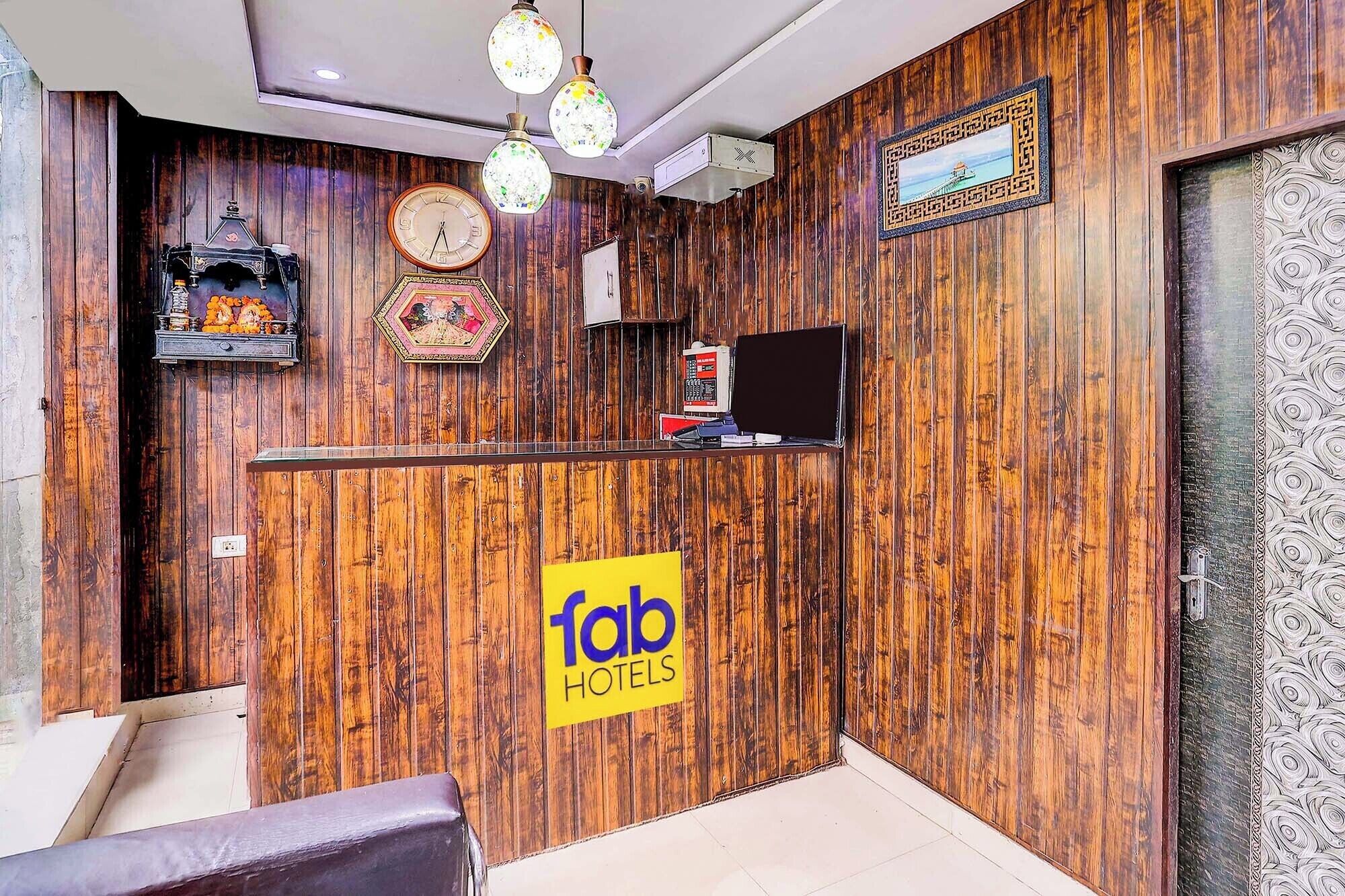Una mesa de recepción con un fondo de madera, un reloj, un adorno de pared y un televisor.