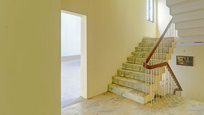 A staircase with a wooden handrail leading to a landing. - Fabhotel Anant (Lucknow)