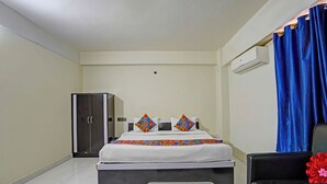 A hotel room with a bed, a wardrobe, a desk, and a chair.