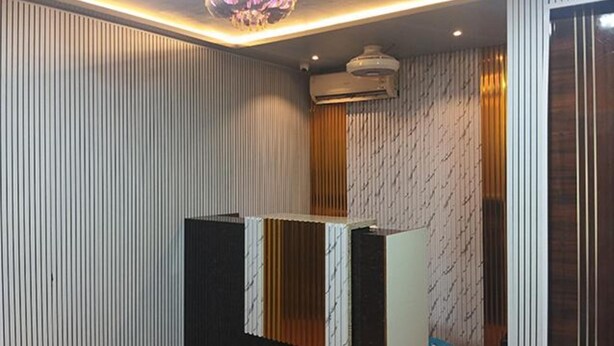 A reception area with a modern design, featuring vertical paneling on the walls and a central reception desk. - Fabhotel Arya Baner (Pune)