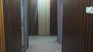 A narrow hallway with wooden doors and a herringbone-patterned floor. - Fabhotel Arya Baner (Pune)