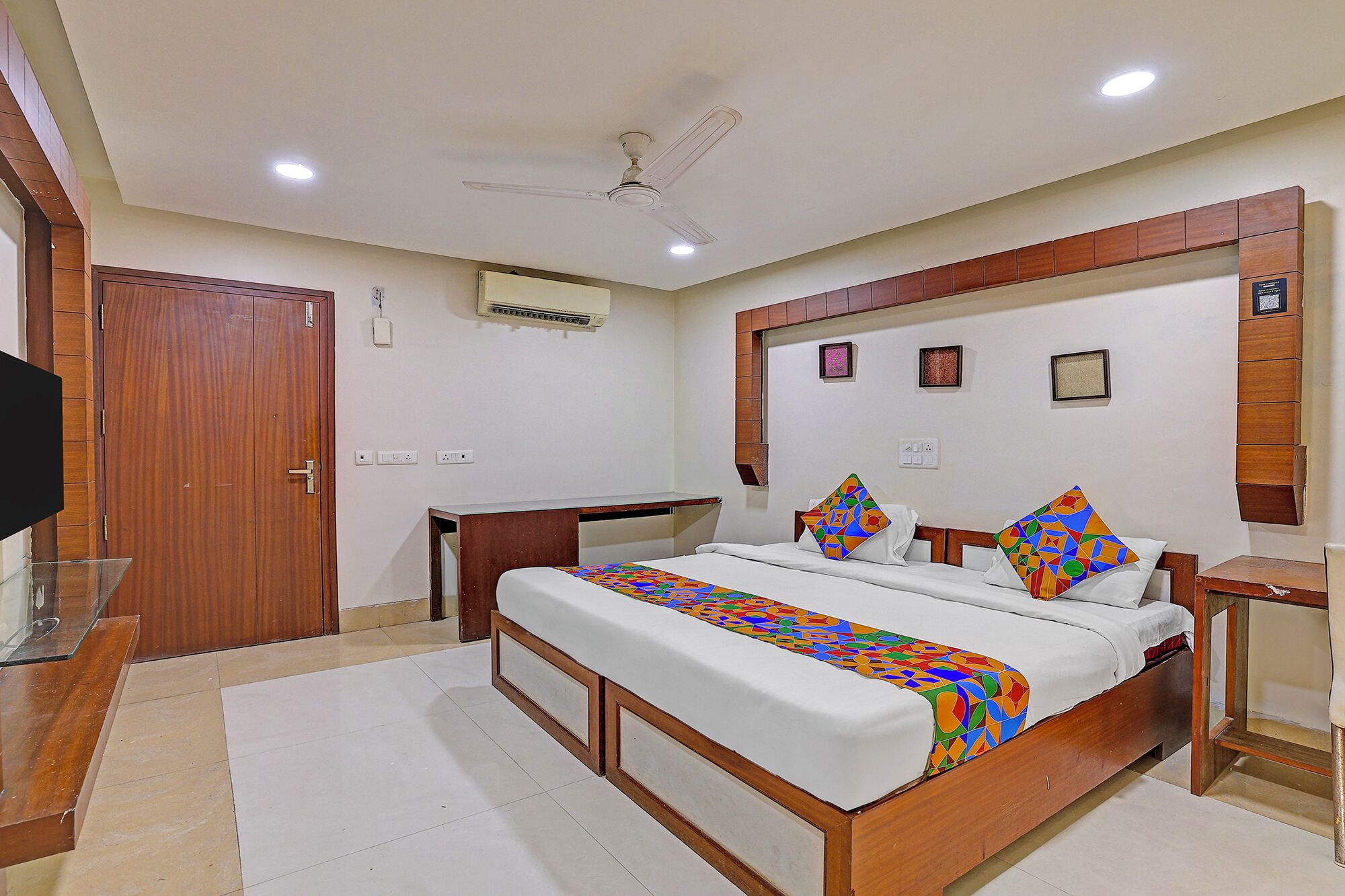 A bedroom with a bed, bedside tables, a desk, and a wardrobe.