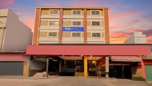 A multi-story hotel with a prominent 'fabHOTELS' sign, a covered entrance, and a modern architectural design. - Fabhotel Alfa (Vijayawada)