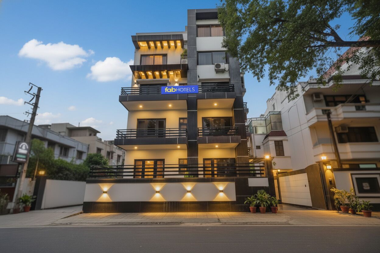 Um hotel de vários andares com design moderno, com varandas e uma entrada bem iluminada.