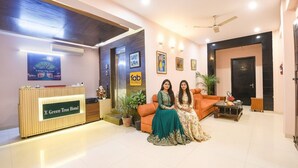 A reception area with a reception desk labeled "X Green Tree Hotel," a sofa, a coffee table, and a ceiling fan. - Fabhotel X Green Tree (Gurugram)