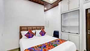 Un dormitorio con cama, cabecero, mesita de noche, armario y puerta.