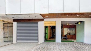 Una entrada de edificio moderna con un toldo enrollable cerrado, techo de madera y suelo de baldosas.