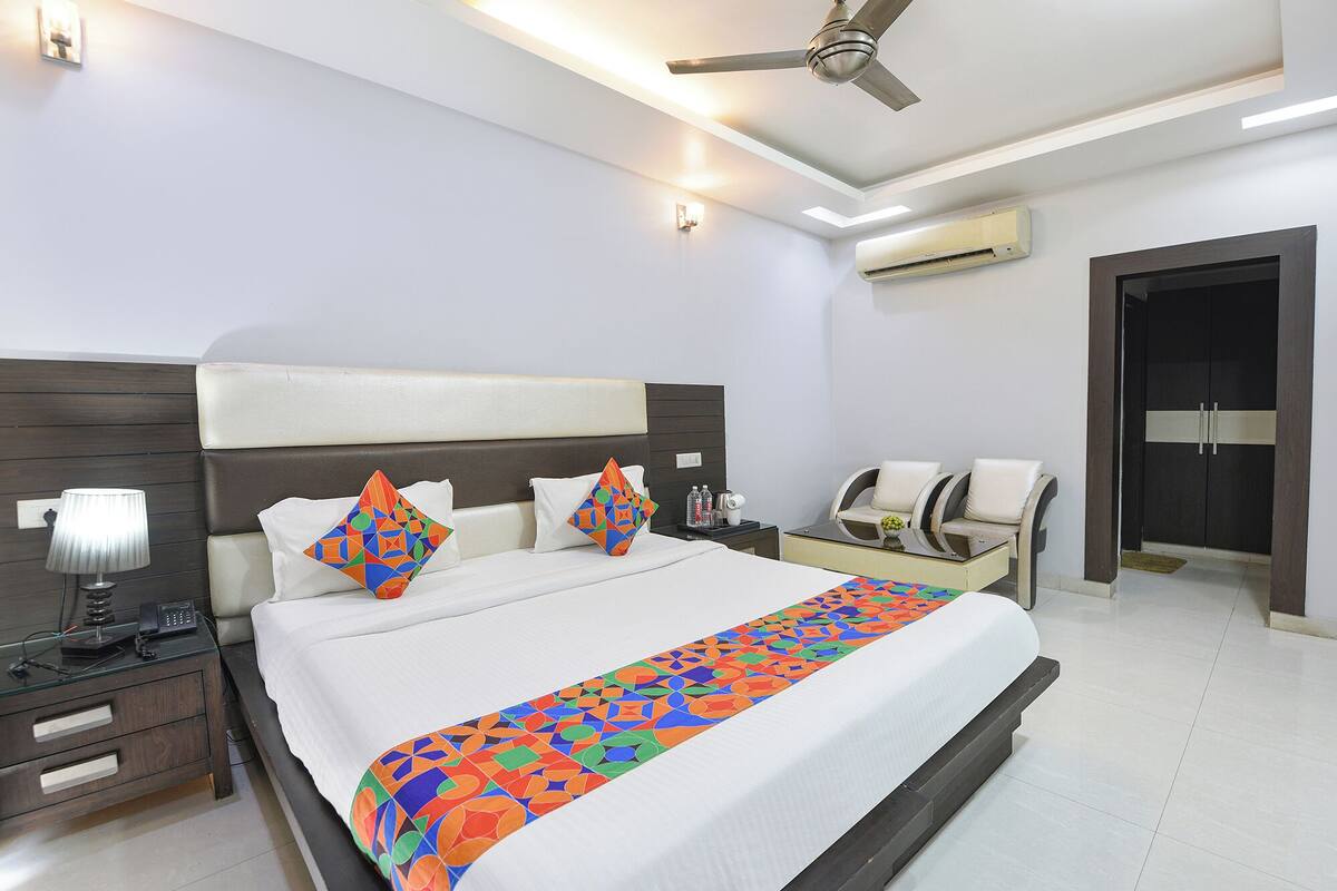 Une chambre d’hôtel comprenant un lit, des tables de chevet, un bureau, une chaise et une armoire.