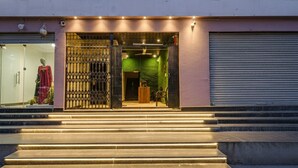 A building entrance with steps leading up to a gated door. - Fabhotel Cube (Hyderabad)