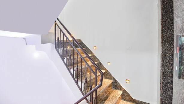 Una escalera moderna con barandilla de metal y peldaños de granito.