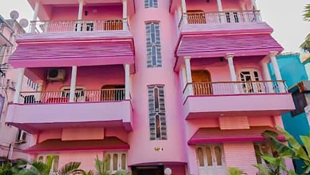 A multi-story pink building with balconies and a central staircase. - Fabhotel Sonar Bangla (Barasat)