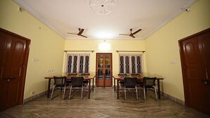 A room with a marble floor, two wooden doors, a glass door, and a ceiling fan. - Fabhotel Sonar Bangla (Barasat)