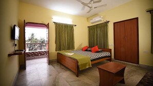 A room with a bed, a desk, a wardrobe, and a television. - Fabhotel Sonar Bangla (Barasat)