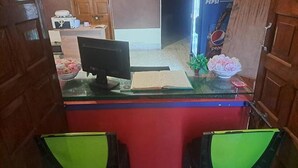 A kitchen area with a microwave, a bowl of food, a book, and a Pepsi refrigerator. - Fabhotel Sonar Bangla (Barasat)