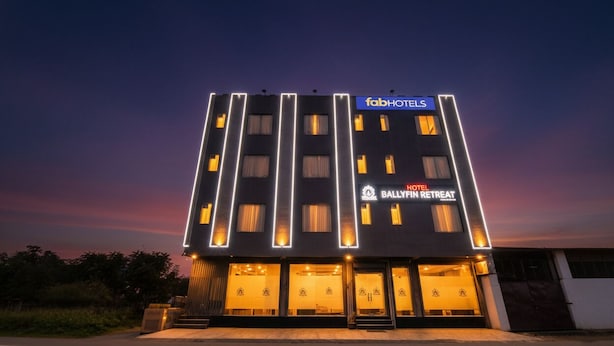 Ein modernes Hotelgebäude mit einem Schild für 'fabHOTELS' und 'BALLYFIN RETREAT' bei Nacht.