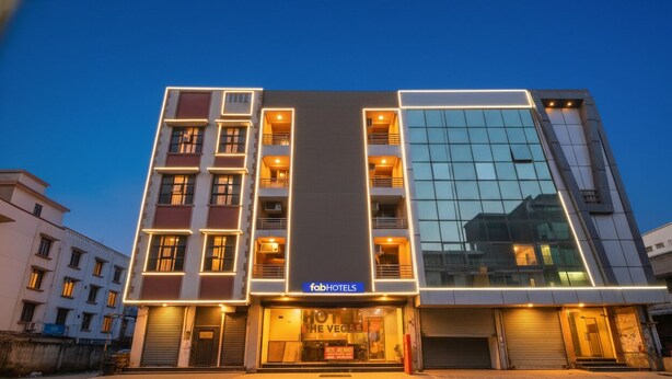 Un hôtel moderne doté d’une façade en verre, de nombreux balcons et d’une enseigne « fabHOTELS » bien visible.