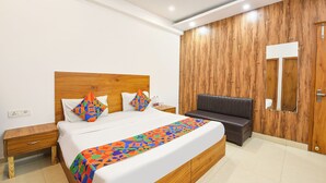 Une chambre à coucher moderne avec une tête de lit en bois, un lit agrémenté de coussins colorés, un banc et une armoire en bois.