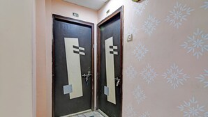 Deux portes surmontées d’une plaque portant le numéro « 501 », un sol en marbre et un mur orné d’un motif floral.