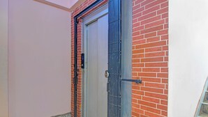 Une porte fermée, dotée d’une serrure électronique, d’une poignée en métal et d’un trou de serrure.