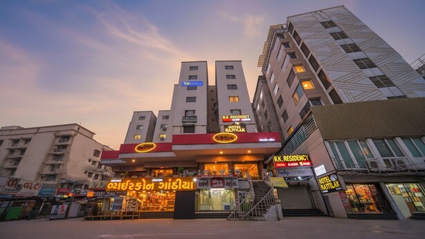 A hotel with multiple floors, a prominent entrance with signage, and a staircase leading to the entrance. - Fabhotel Rajtilak (Ahmedabad)
