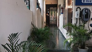 A narrow corridor with potted plants on either side, leading to a door at the end. - Fabhotel Crown Inn (Lucknow)