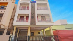 A multi-story building with a sign reading "fabHOTELS". It has balconies with railings, a central staircase, and a gated entrance. - Fabhotel Blue Moon Residency (Chennai)
