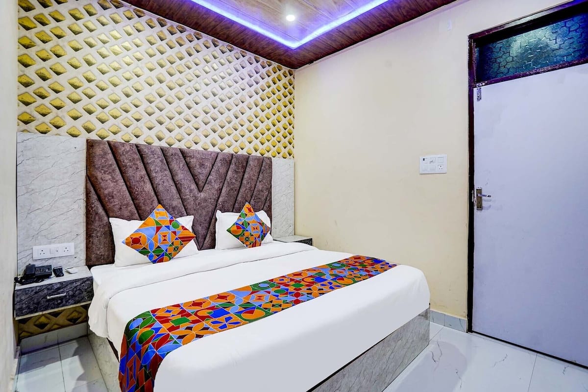 A bedroom with a bed, a headboard, a nightstand, and a door.