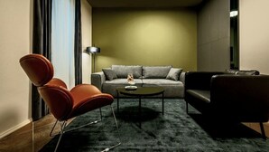 A modern living room with a sofa, two armchairs, a coffee table, and a floor lamp.