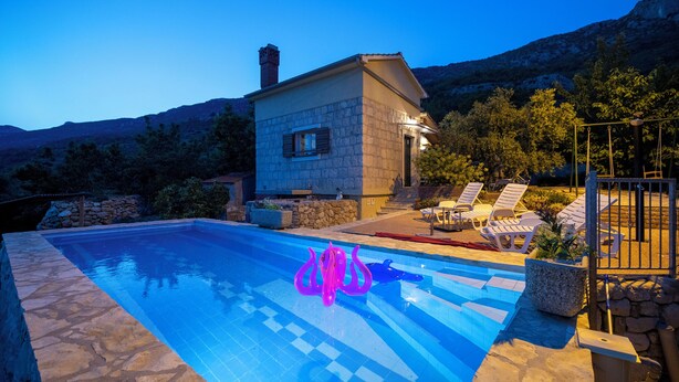 A stone house with a swimming pool, lounge chairs, and a mountain backdrop. - Hill Pool House, Kaštel Kambelovac Retreat (Kaštel Kambelovac)