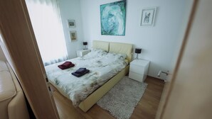 Een slaapkamer met een bed, nachtkastjes, een vloerkleed en kunst aan de muur.