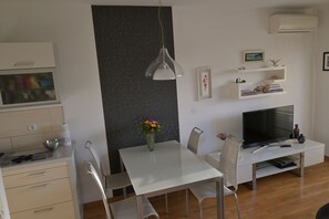 شقة | منطقة المعيشة | تلفزيون بشاشة مسطحة بحجم 30-بوصة يعرض قنوات تلفزيونية باشتراك مدفوع