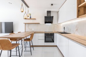Comfort Apartment | Private kitchen | Electric kettle, highchair, dining tables